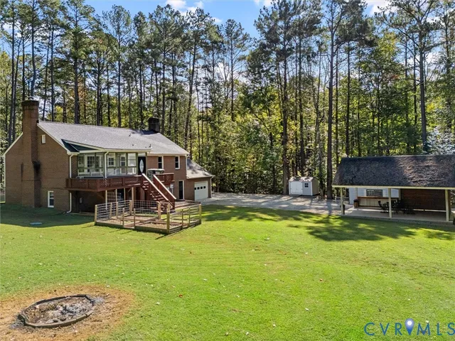 a patio with table and chairs and couches with wooden roof and stairs