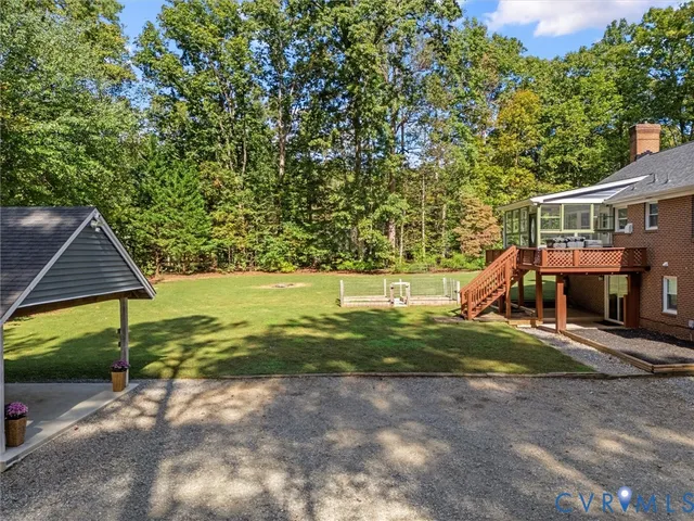 a view of a patio with table and chairs under an umbrella with a barbeque