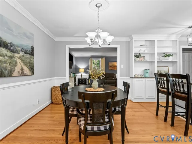 a dining room with furniture a chandelier and wooden floor