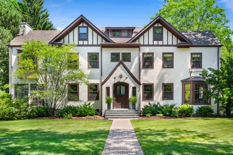 a front view of a house with a yard and green space