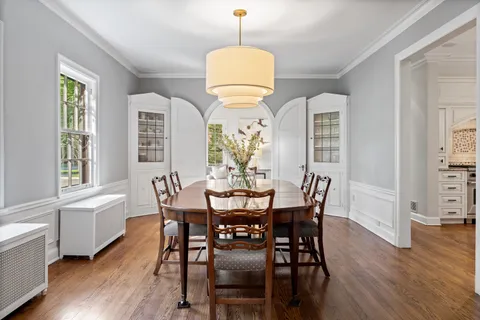 a dining room with furniture a chandelier and wooden floor