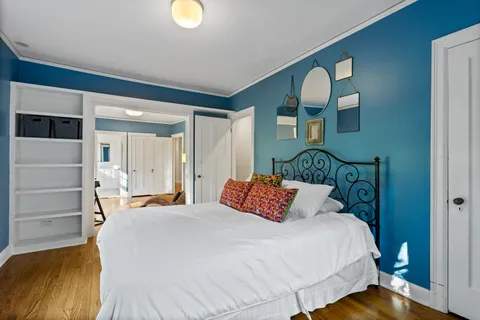 a bedroom with a bed and a lamp on dresser