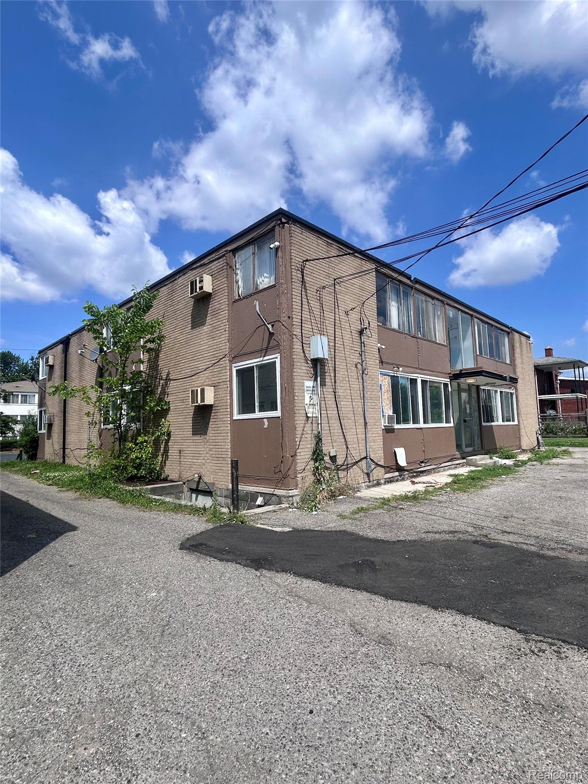 15080 Greenfield Road Detroit, MI 48227 - Photo 3 of 6 Brick exterior building featuring multiple windows and a paved parking area