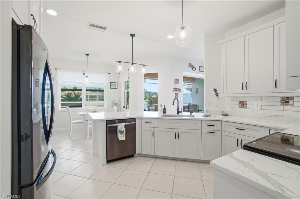 3948 Ruxton Road Naples, FL 34116 - Photo 12 of 43 a kitchen with stainless steel appliances granite countertop a sink and a refrigerator