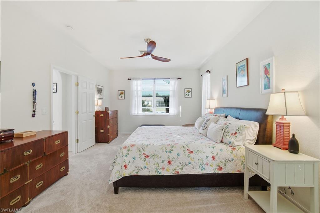 3948 Ruxton Road Naples, FL 34116 - Photo 22 of 43 a bedroom with a bed and a chandelier