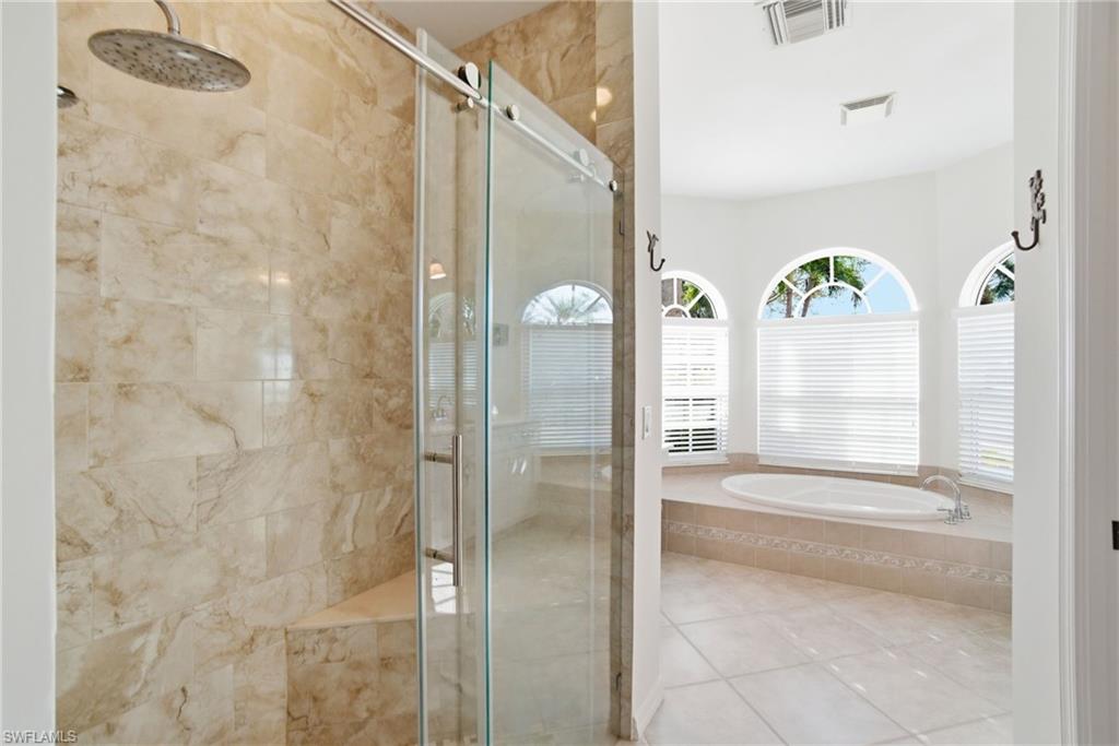 3948 Ruxton Road Naples, FL 34116 - Photo 25 of 43 a bathroom with a glass shower door and a mirror
