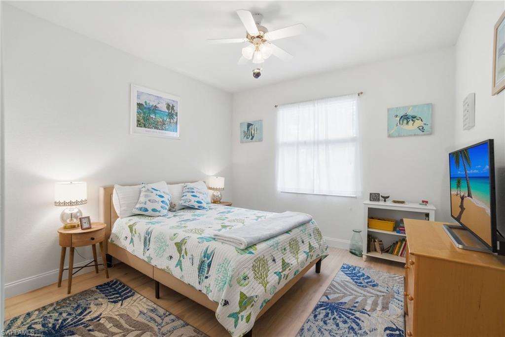 3948 Ruxton Road Naples, FL 34116 - Photo 28 of 43 a bedroom with a bed a table and chair