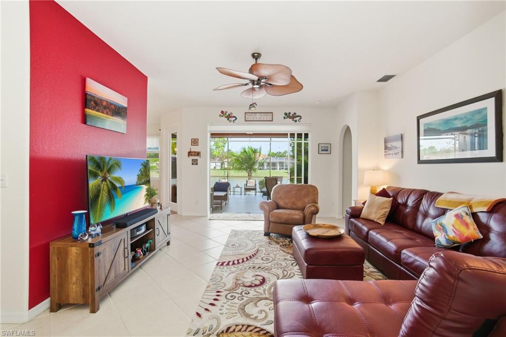 3948 Ruxton Road Naples, FL 34116 - Photo 8 of 43 a living room with furniture a flat screen tv and a floor to ceiling window