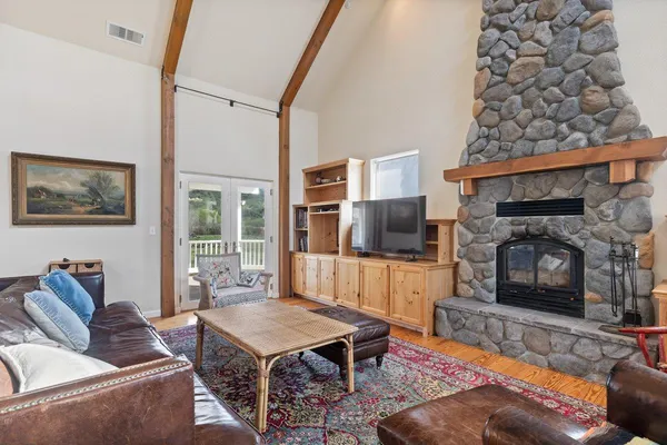 a living room with furniture a flat screen tv and a fireplace