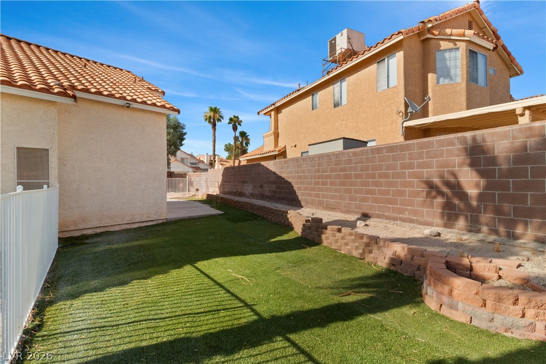 3156 Terrace View Drive Laughlin, NV 89029 - Photo 65 of 94 A well-maintained yard features artificial turf and a durable block wall, ready for outdoor enjoyment.