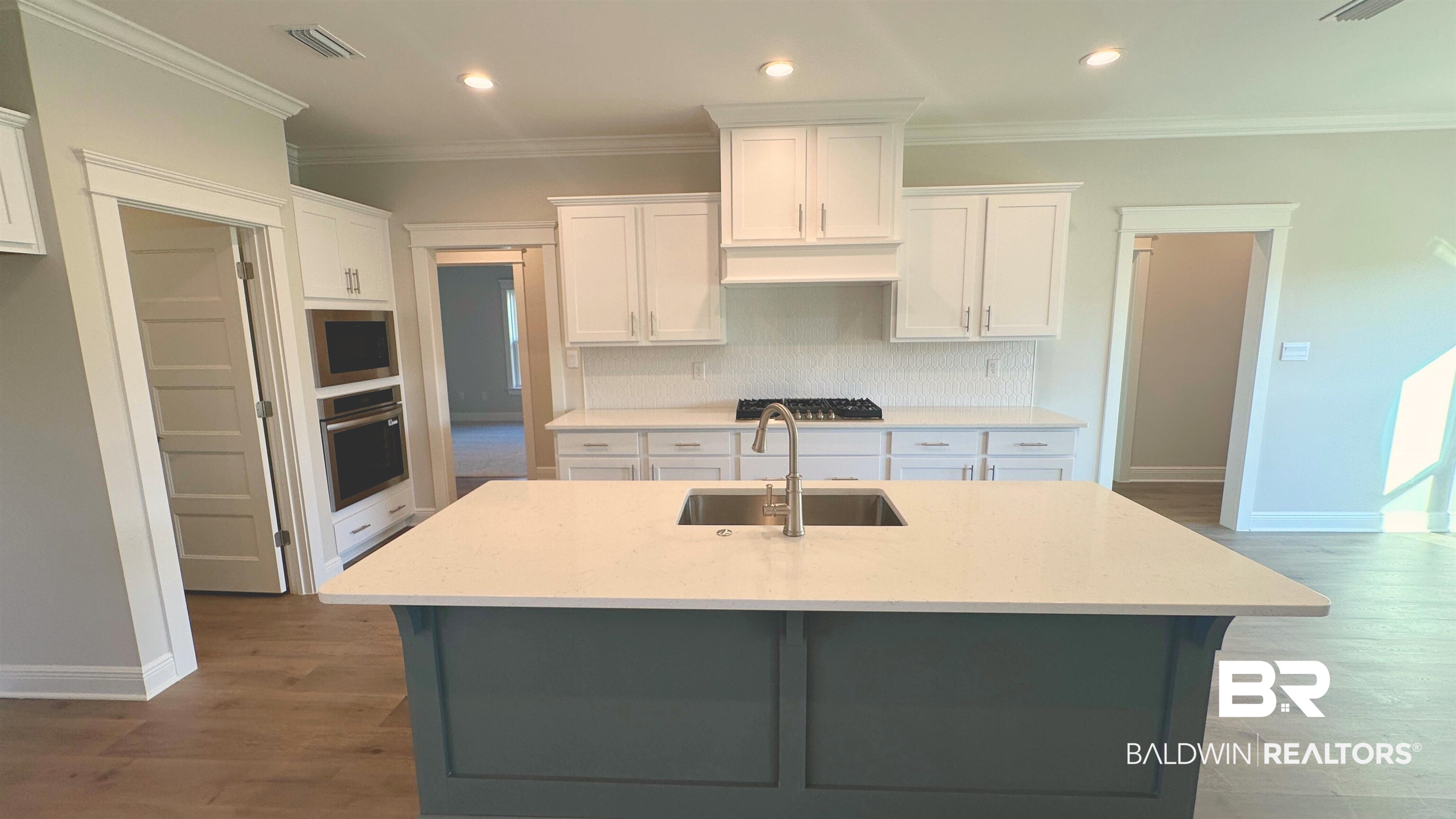 126 Daybreak Trail Fairhope, AL 36532 - Photo 9 of 34 Kitchen with white cabinetry, recessed lighting, a center island with sink, light stone counters, and appliances with stainless steel finishes