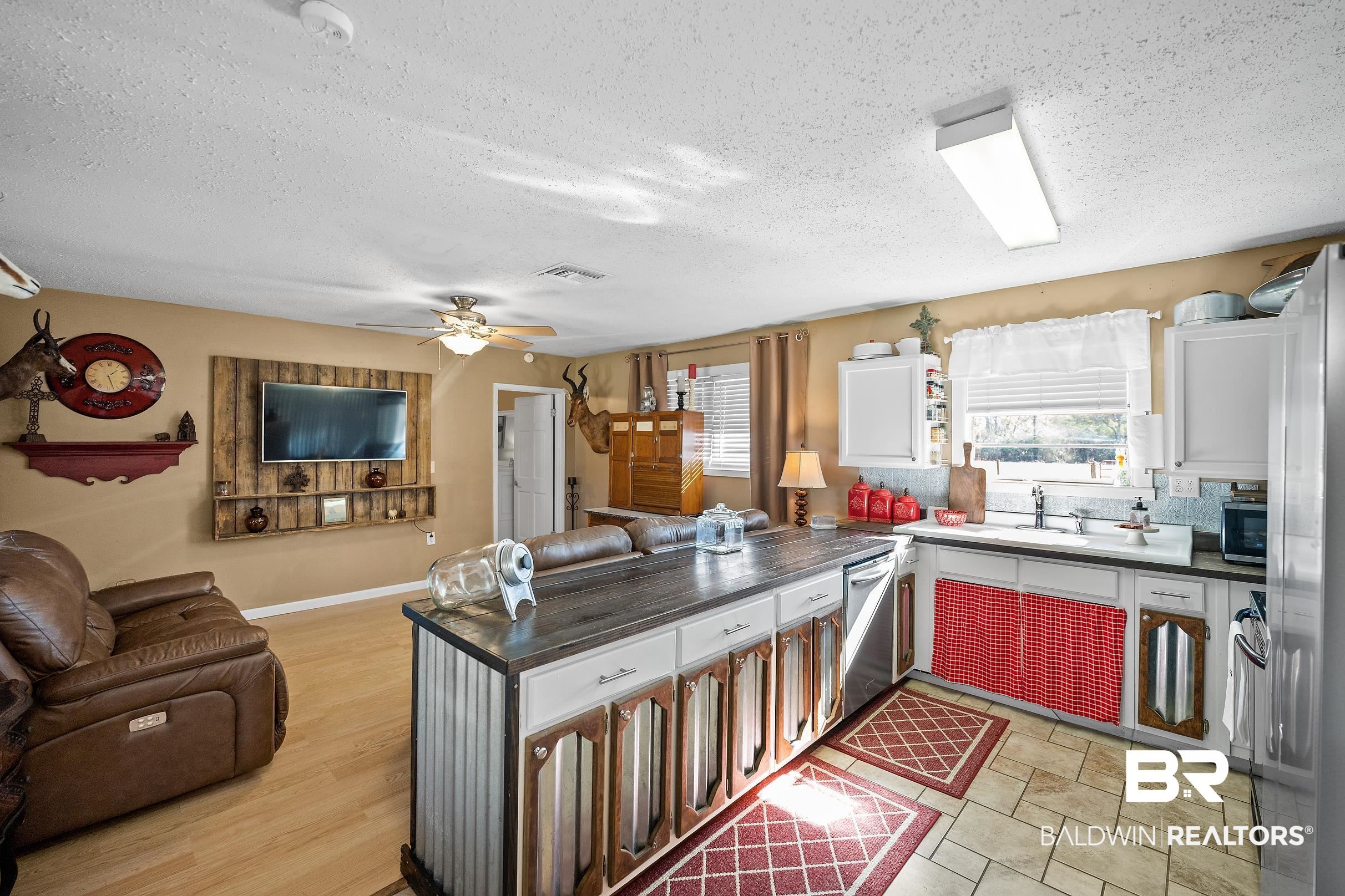 110 Sam Jones Road Atmore, AL 36502 - Photo 43 of 47 Kitchen with dark countertops, a peninsula, open floor plan, plenty of natural light, and a textured ceiling