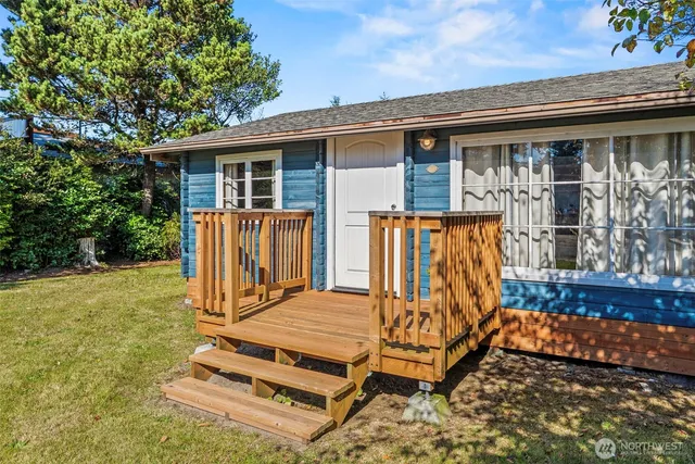front view of a house with barbeque grill and wooden fence