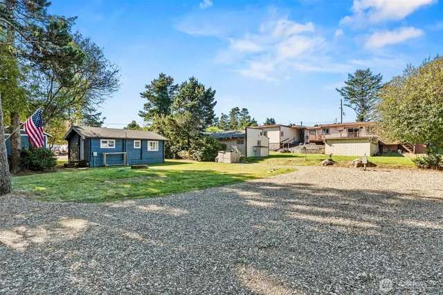 a view of a house with a big yard and large trees