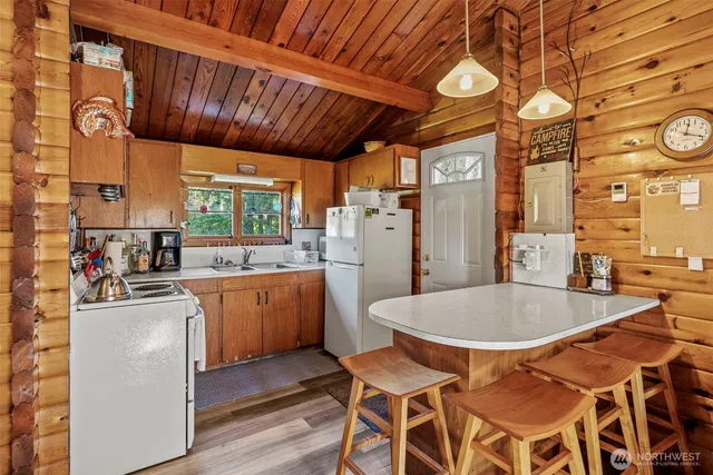 a kitchen with a dining table chairs sink and cabinets