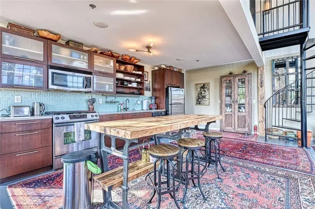 a kitchen with stainless steel appliances granite countertop a stove top oven a sink and cabinets
