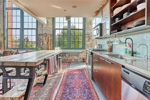 a dining hall with stainless steel appliances granite countertop a stove and a sink
