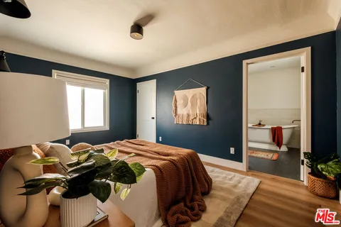 a bed sitting in a bedroom next to a window