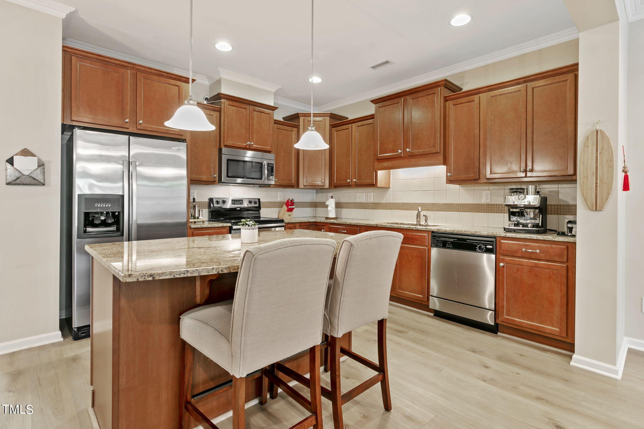 2428 Memory Ridge Drive Raleigh, NC 27606 - Photo 11 of 36 a kitchen with stainless steel appliances granite countertop a refrigerator a stove top oven a sink dishwasher and white cabinets with wooden floor