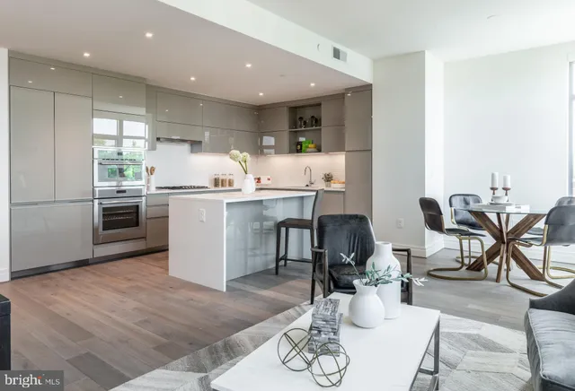 a kitchen with stainless steel appliances granite countertop a table and chairs in it