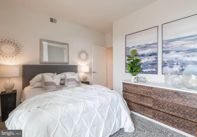 a large white bed sitting in a bedroom next to a window