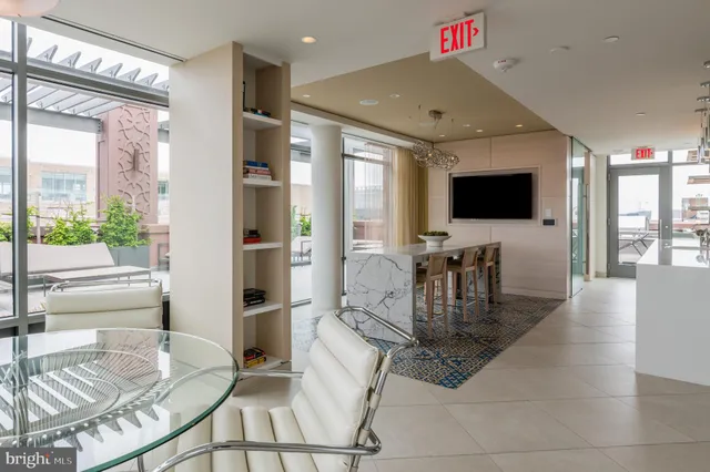 a work room with furniture a flat screen tv and a large window