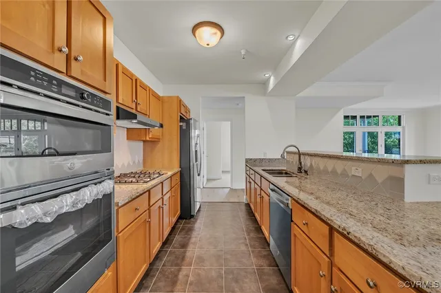 a kitchen with stainless steel appliances granite countertop a sink and a stove