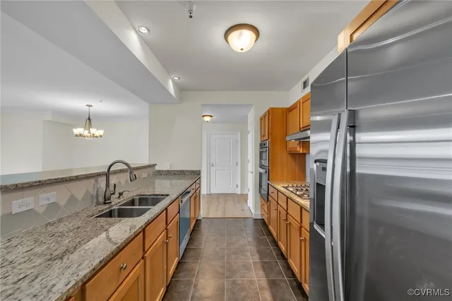 a kitchen with granite countertop a sink and refrigerator