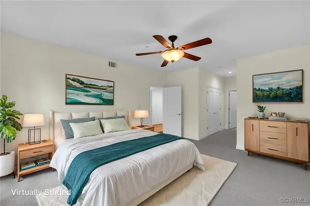 a bedroom with a large bed and a chandelier