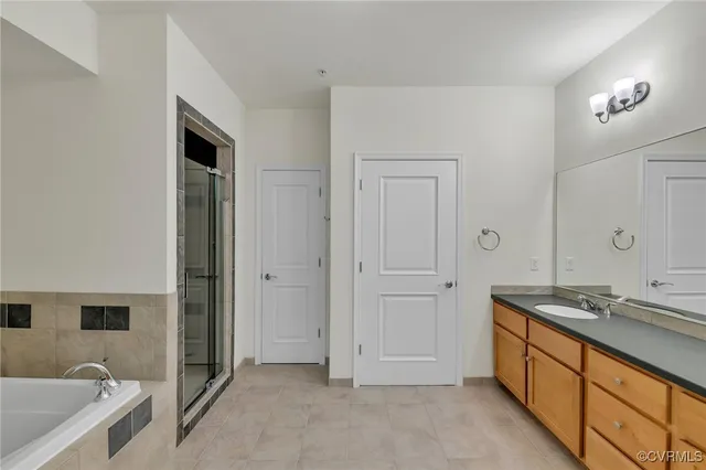 a spacious bathroom with a granite countertop sink and a bathtub