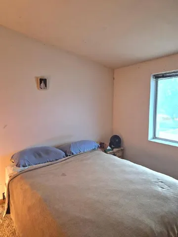 a bedroom with a bed and window