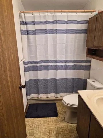 a bathroom with a toilet and a shower curtain