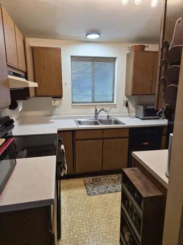 a kitchen with a sink a stove and cabinets