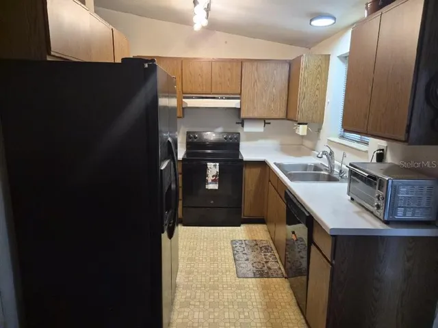 a kitchen with a sink refrigerator and cabinets