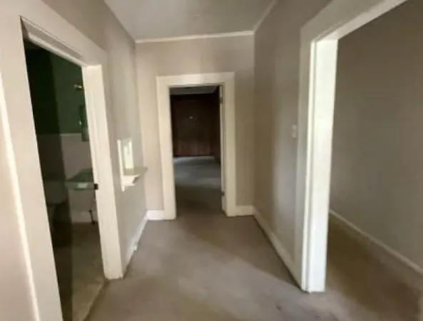 a view of empty room with wooden floor and window