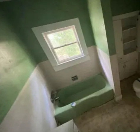 a bathroom with a toilet and a window