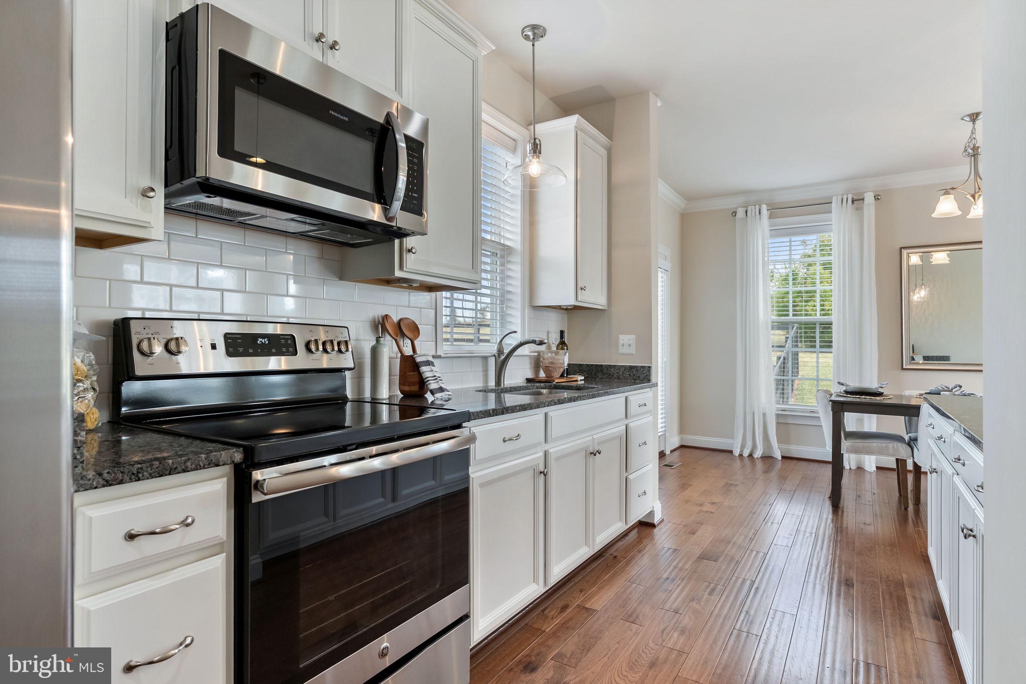 18482 Wild Raspberry Drive Purcellville, VA 20132 - Photo 122 of 143 a kitchen with stainless steel appliances a stove microwave and cabinets