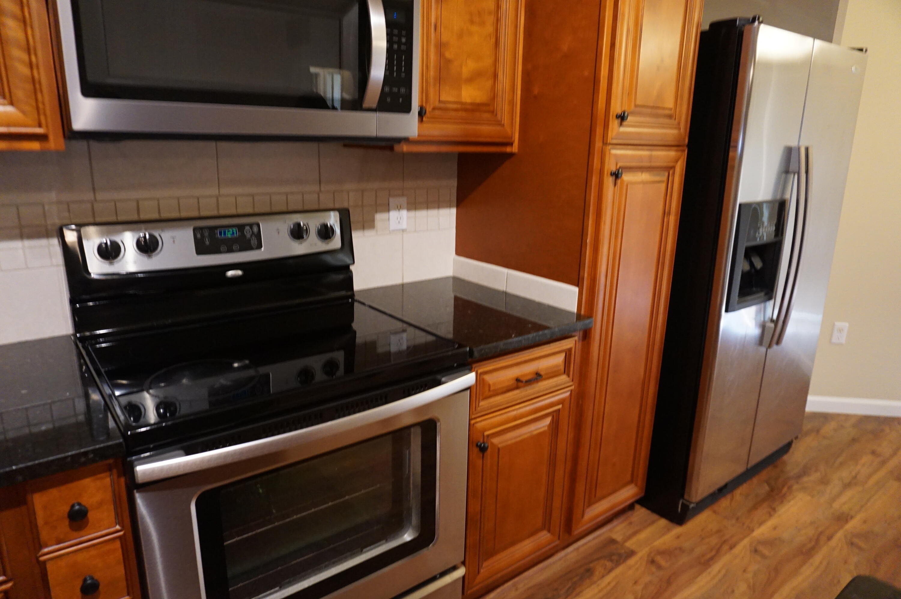 5263 Moore Loop Crestview, FL 32536 - Photo 11 of 37 a kitchen with wooden cabinets and a stove top oven