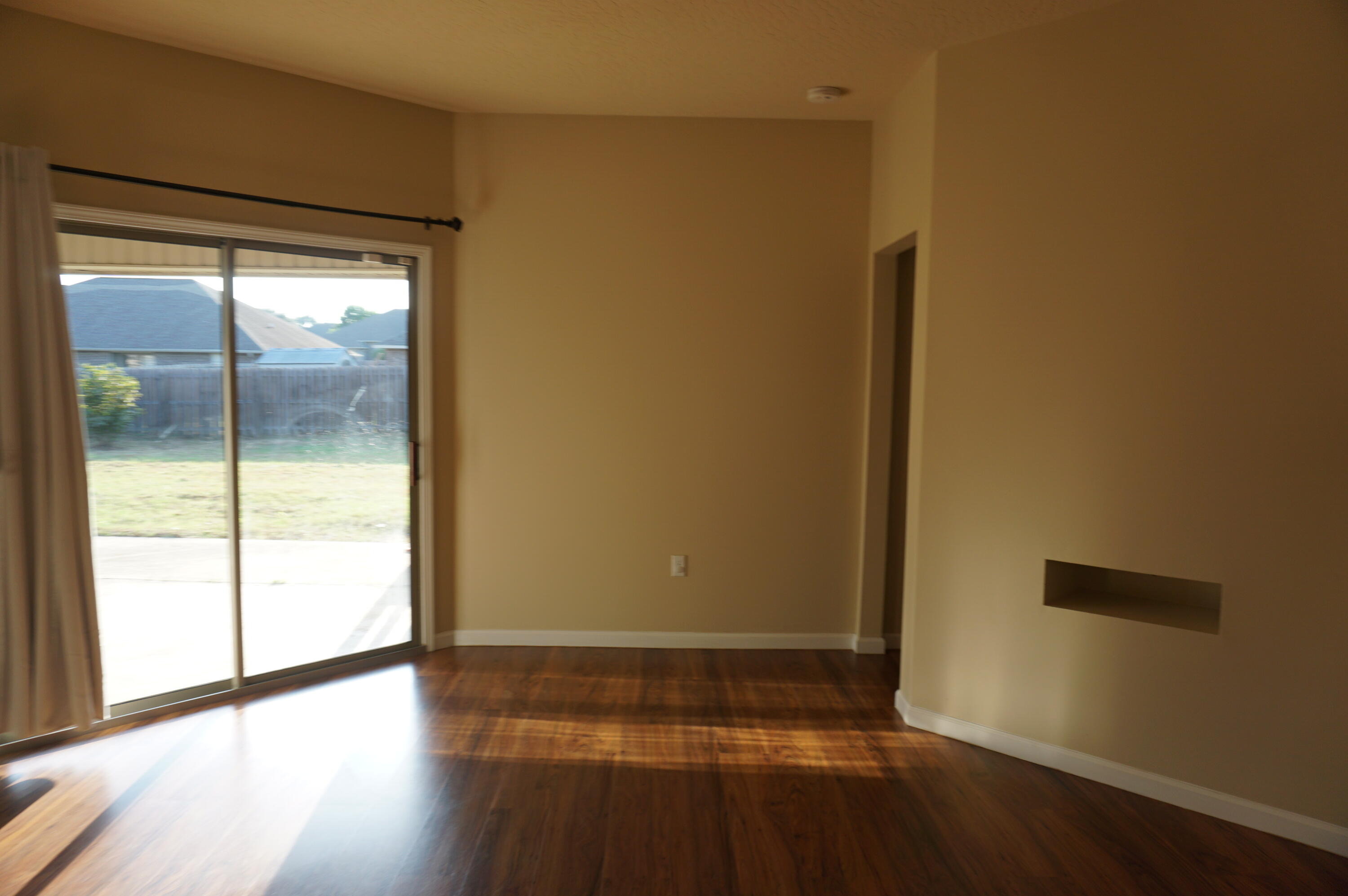 5263 Moore Loop Crestview, FL 32536 - Photo 14 of 37 a view of an empty room with wooden floor and a window