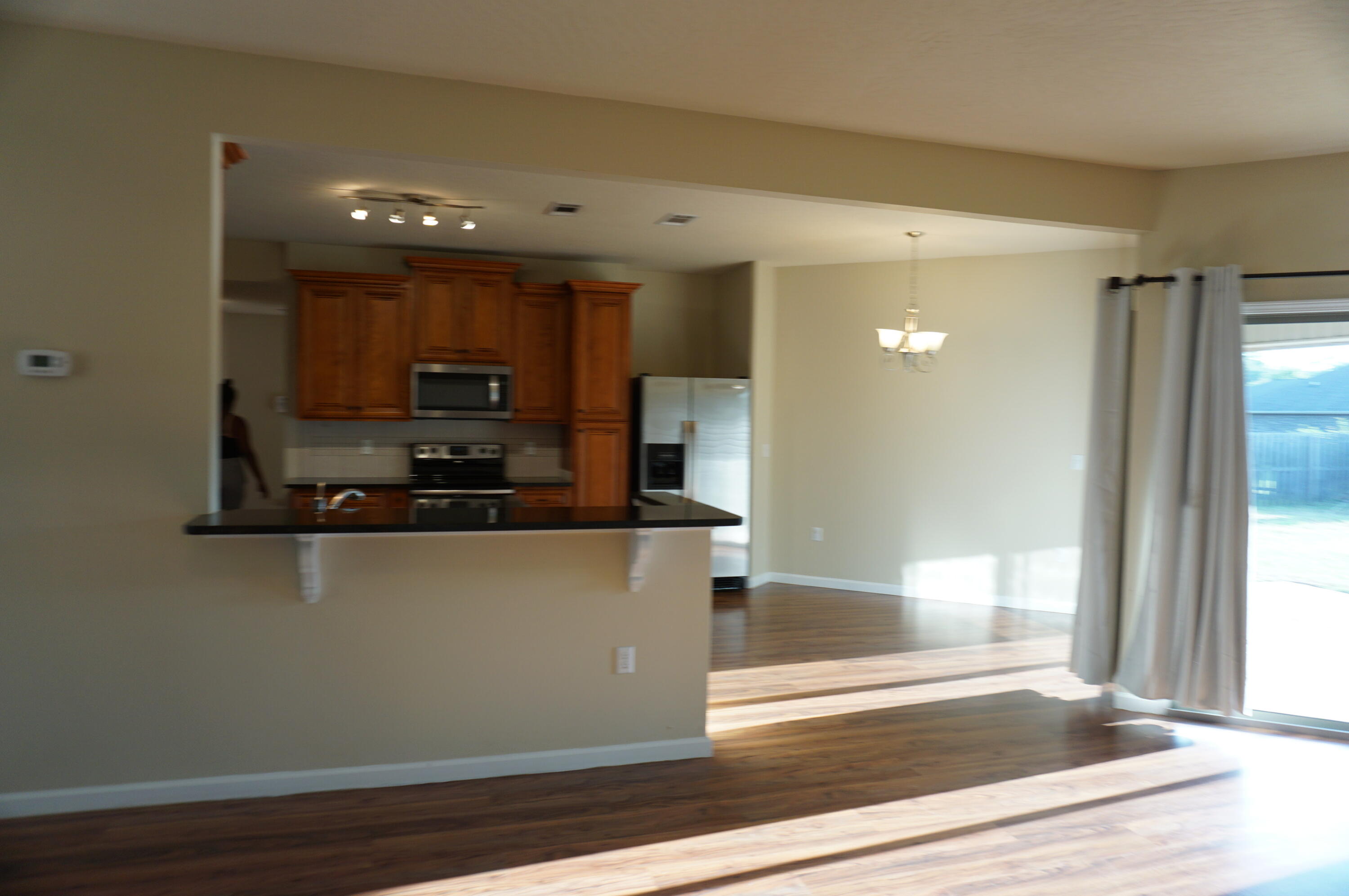 5263 Moore Loop Crestview, FL 32536 - Photo 9 of 37 a view of a kitchen with wooden floor and a glass door