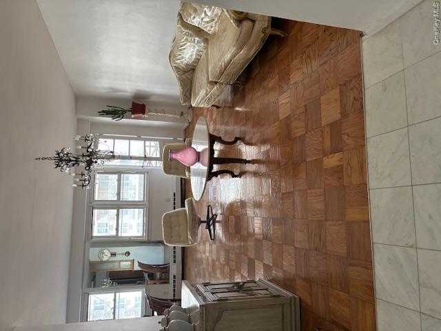 450 Shore Road, Unit 4H Long Beach, NY 11561 - Photo 5 of 17 a living room with furniture and a chandelier