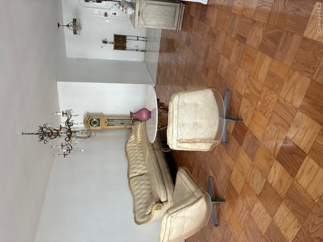 450 Shore Road, Unit 4H Long Beach, NY 11561 - Photo 6 of 17 a living room with couch and a chandelier