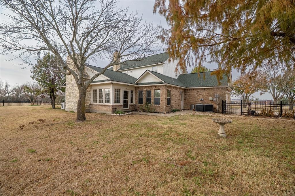 364 Parker Road, Unit A Van Alstyne, TX 75495 - Photo 26 of 39 Rear exterior featuring a sunroom, brick and stone facade, and a fenced perimeter