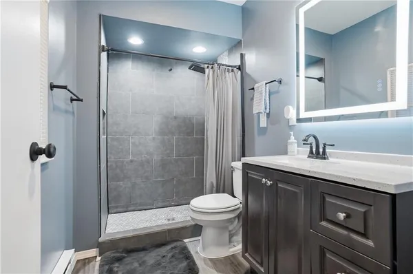 a bathroom with a granite countertop sink toilet and shower