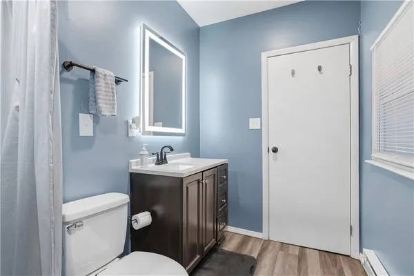 a bathroom with a granite countertop toilet a sink and mirror
