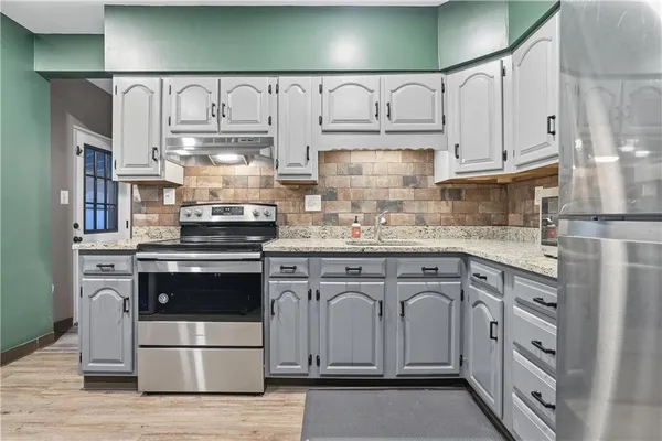 a kitchen with stainless steel appliances granite countertop a sink and cabinets