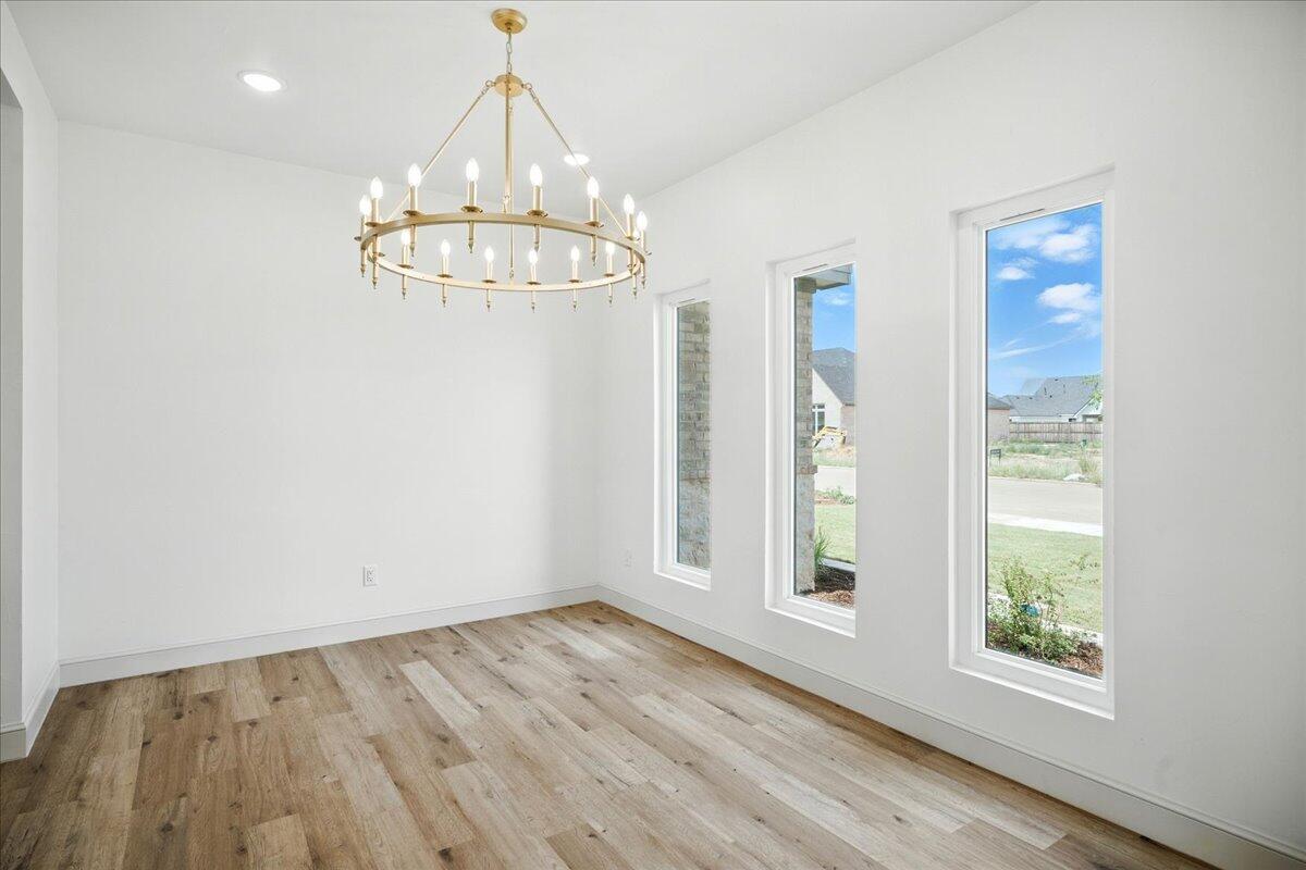 3615 143rd Street Lubbock, TX 79423 - Photo 8 of 32 a view of an empty room with wooden floor and a window