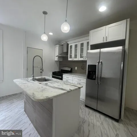 a kitchen with kitchen island a counter top space cabinets and stainless steel appliances