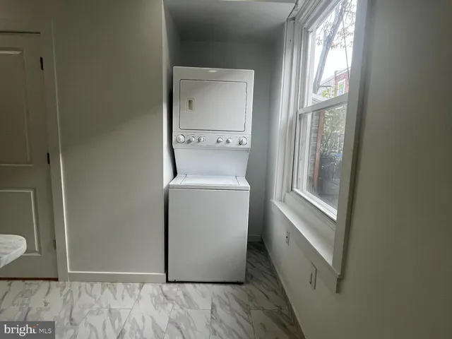 a utility room with wooden floor washer and dryer