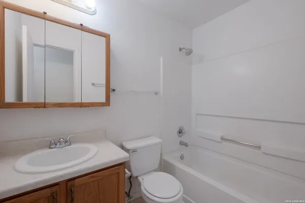 a bathroom with a sink toilet vanity and shower